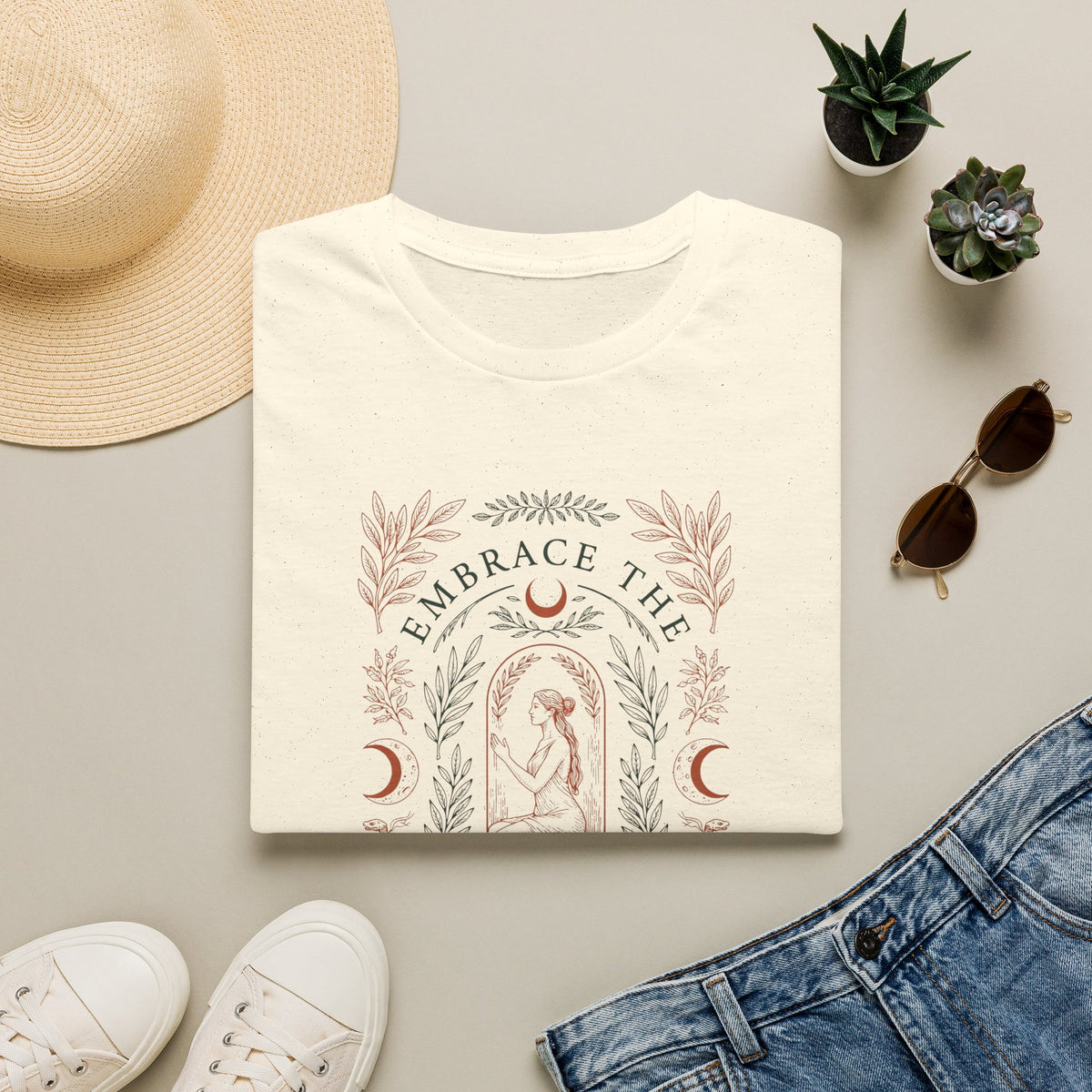 T-shirt with motivational quote surrounded by casual items on a light surface