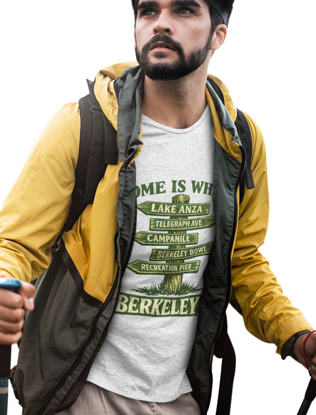 A man wearing a yellow and dark gray zip-up hoodie over a white graphic t-shirt with green 'Berkeley' street sign text, paired with khaki pants and a black beanie, holding hiking poles against a white background.