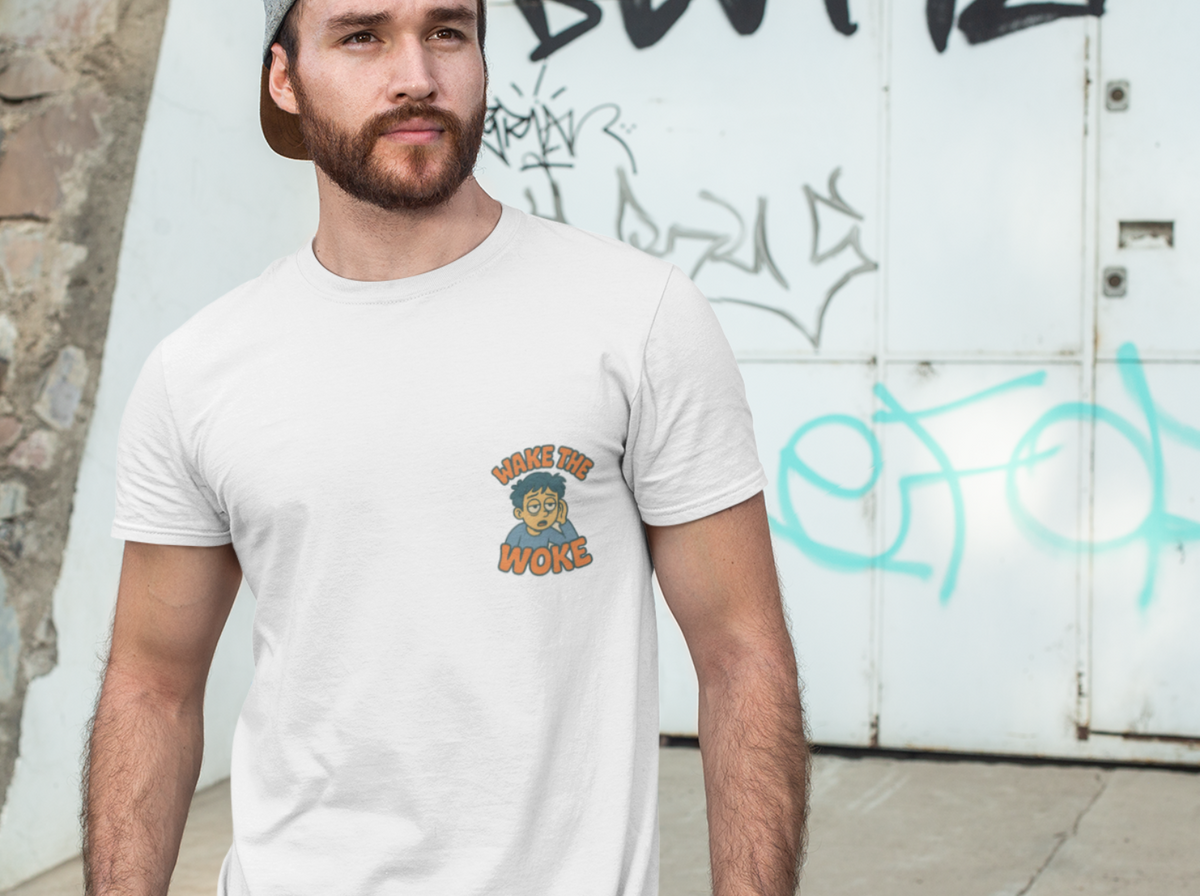 A man wearing a white crewneck t-shirt with a small graphic on the left chest, paired with a gray cap and jeans, standing outdoors against a graffiti-covered white wall.