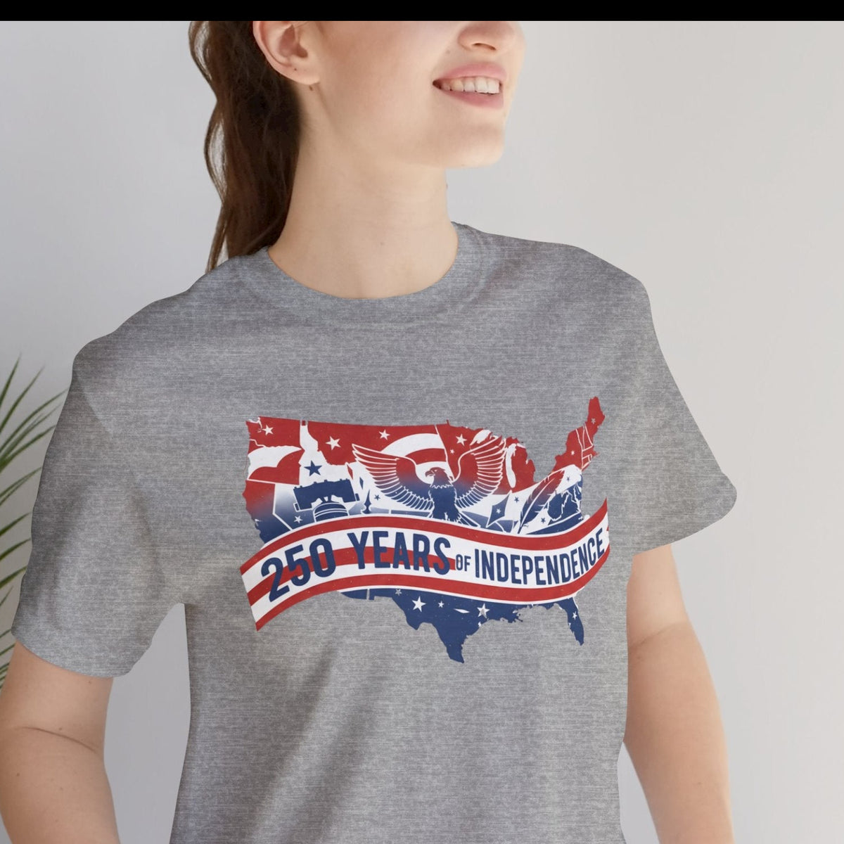 A woman wearing a heather gray t-shirt with a patriotic red, white, and blue graphic of the United States map and the text '260 YEARS OF INDEPENDENCE'.